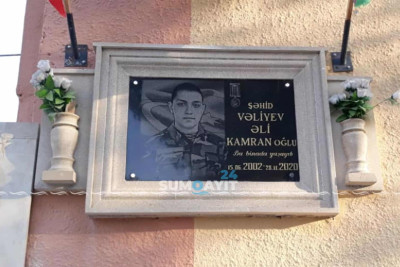 Qazi ailəsi qonşuları olmuş şəhidə xatirə lövhəsi quraşdırır